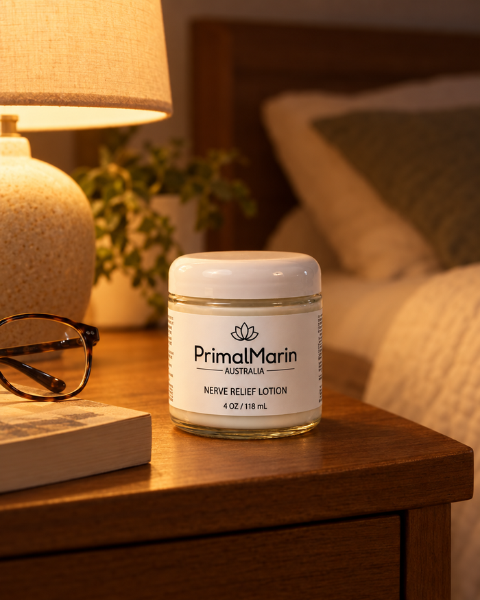 PrimalMarin jar on a nightstand beside a lamp and reading glasses