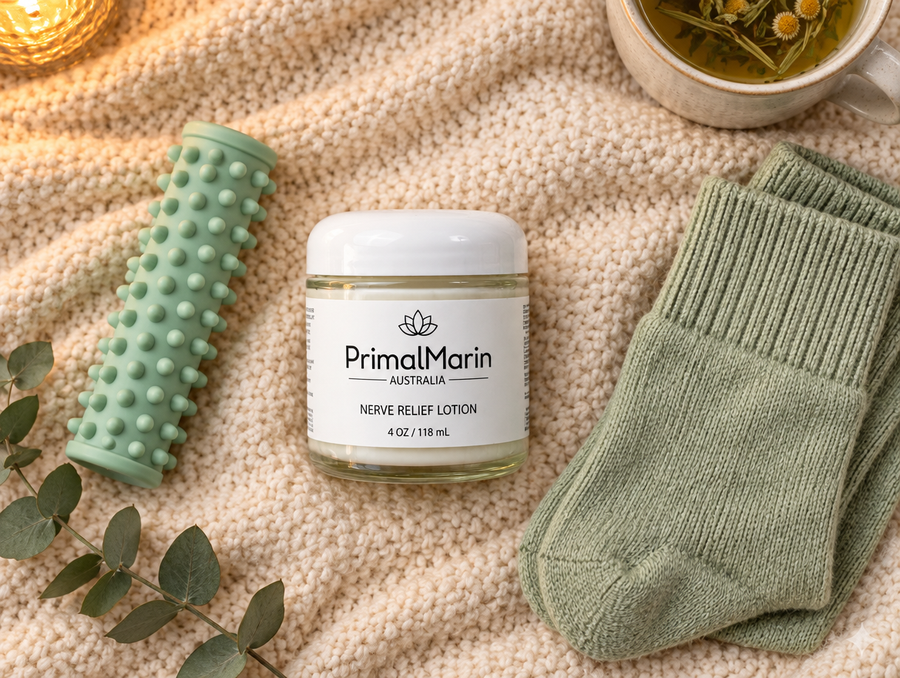 PrimalMarin lotion with a foot roller and cotton socks on a blanket